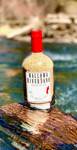 11 oz. bottle resting on rock in the Wallowa River